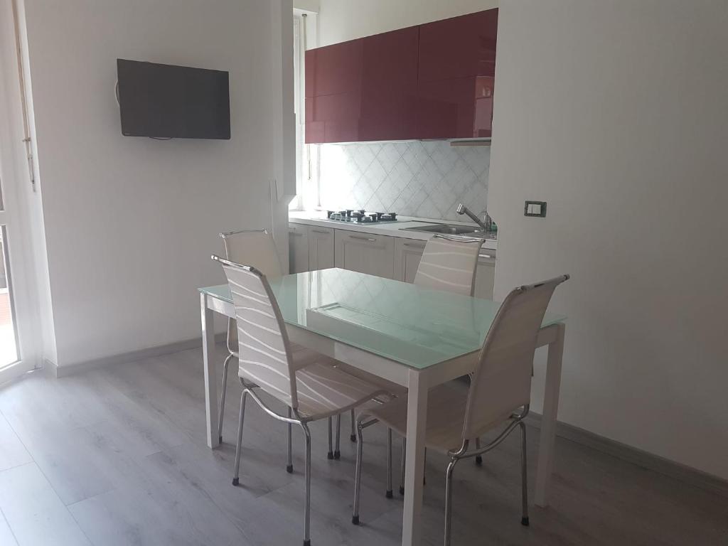 una cocina con mesa de cristal y sillas. en Santa Rita, en Turín