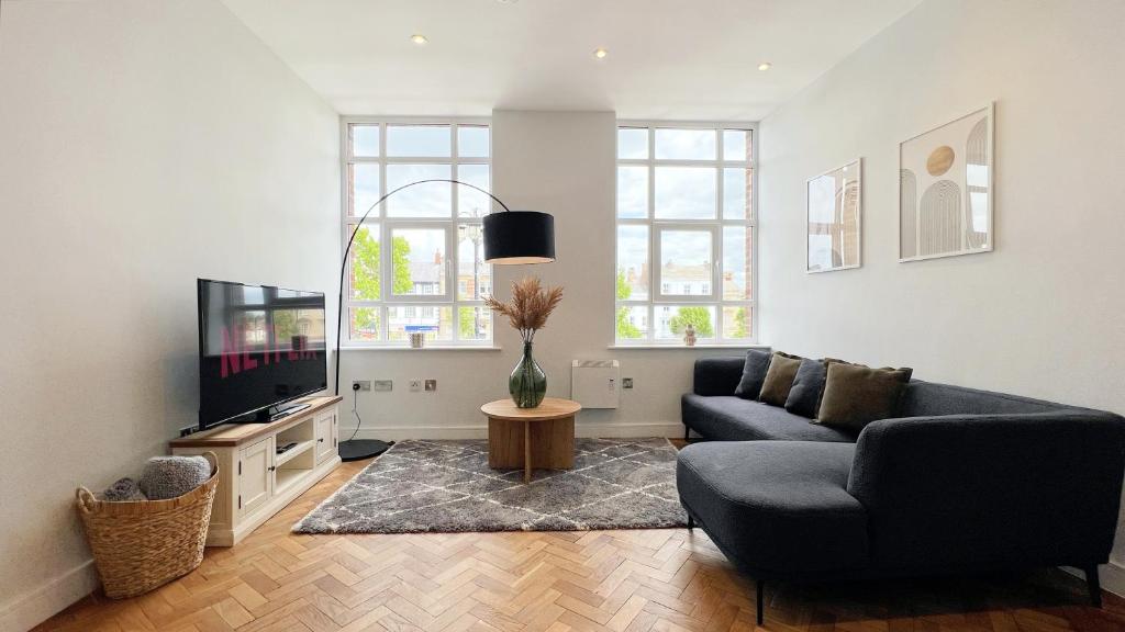 a living room with a couch and a tv at The Yorkshire Hosts - The Tailor's Lounge in Ripon