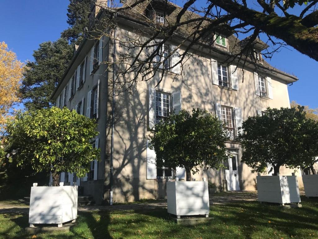 an old building with trees in front of it at Beau château dans le Cantal au coeur du Pays Vert in Naucelles