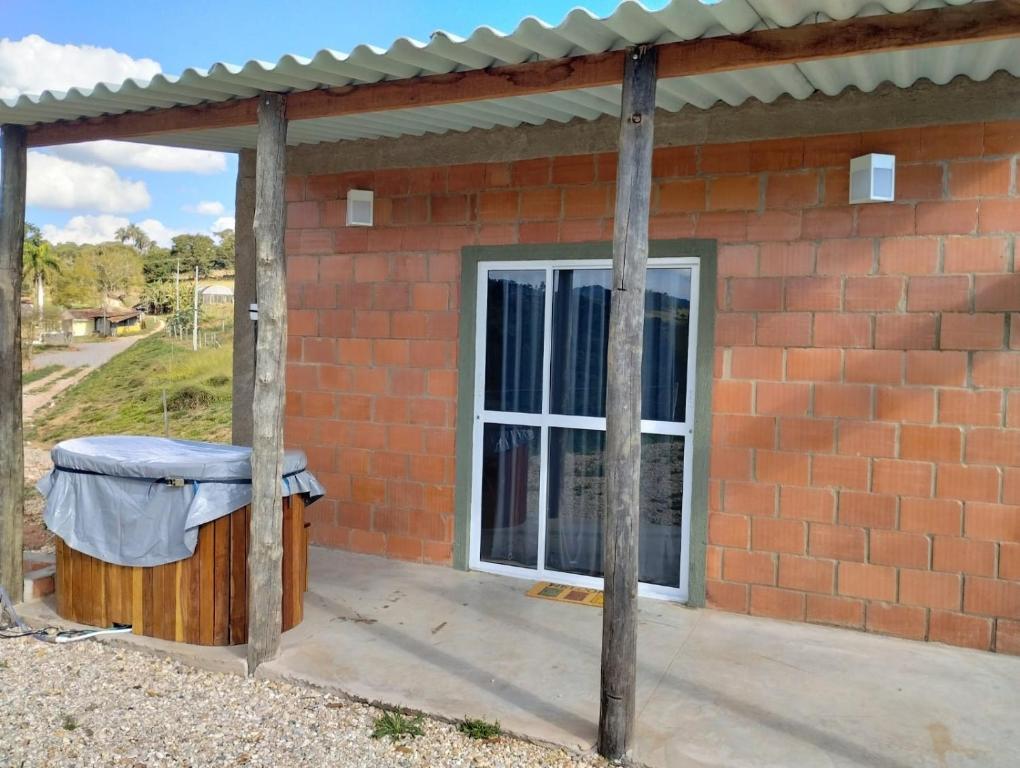 a brick house with a window and a trash can at Bangalô Alto da Pedreira in Socorro