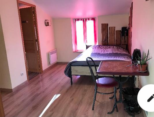1 dormitorio con cama, mesa y escritorio en Chez Franck et Sandra, en Sainte-Menehould