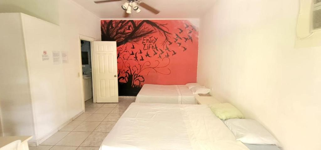 拉塞瓦的住宿－hotel trinidad，墙上画画的房间里设有两张床