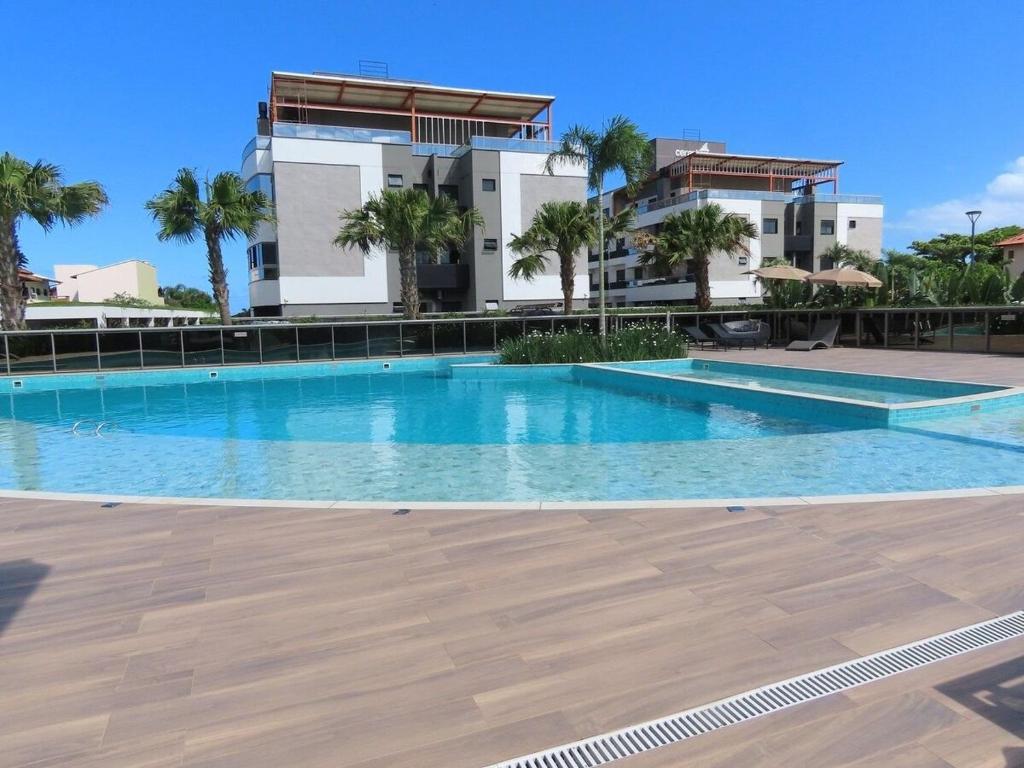 a large swimming pool in front of a building at Apartamento Garden em condomínio clube in Florianópolis