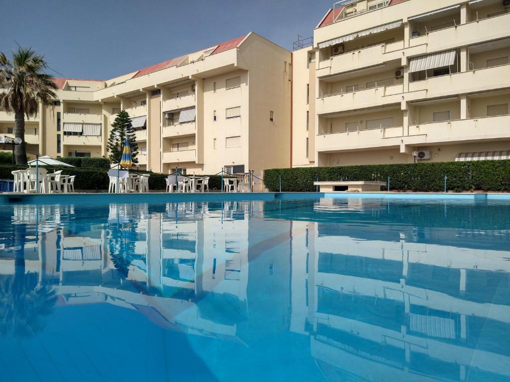 une grande piscine en face d'un bâtiment dans l'établissement Brezza Marina Apartment, à Trapani