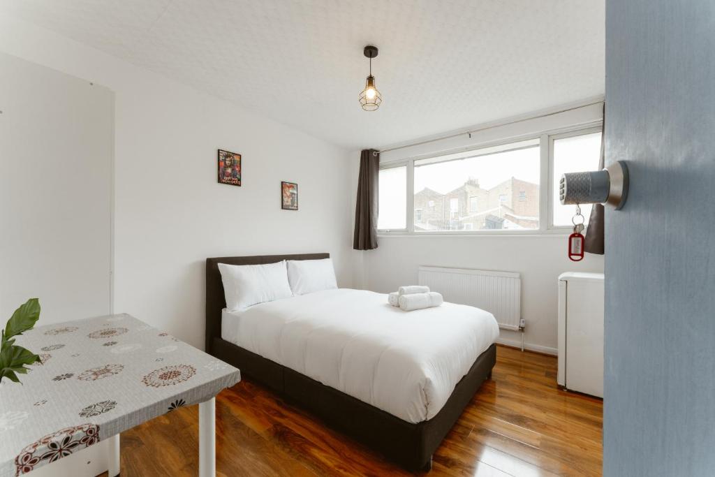 a bedroom with a white bed and a window at CanningTown Double Rooms - 20 in London