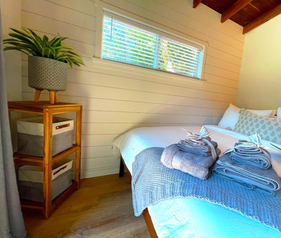 1 Schlafzimmer mit 2 Betten und einem Tisch mit Handtüchern in der Unterkunft Private Wine Country-River Bungalow! Sunny Treetop Views - Pets Stay Free in Forestville