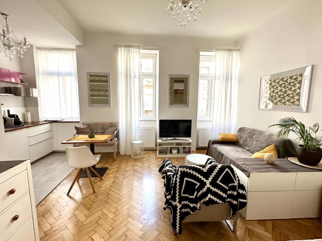 Il comprend un salon avec un canapé et une table. dans l'établissement Cozy city Apartment close to metro - Self Check-in, à Vienne