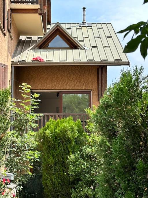 een huis met een dak met struiken ervoor bij Charmant appartement in Briançon