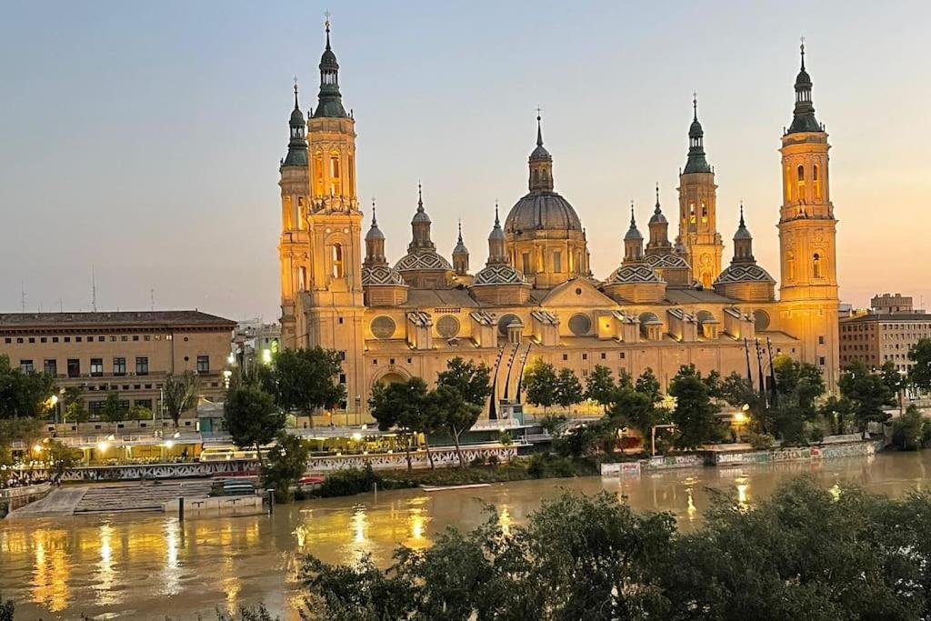 a large building with a river in front of it at Apartamento Con Vistas Al Pilar con Aparcamiento privado in Zaragoza