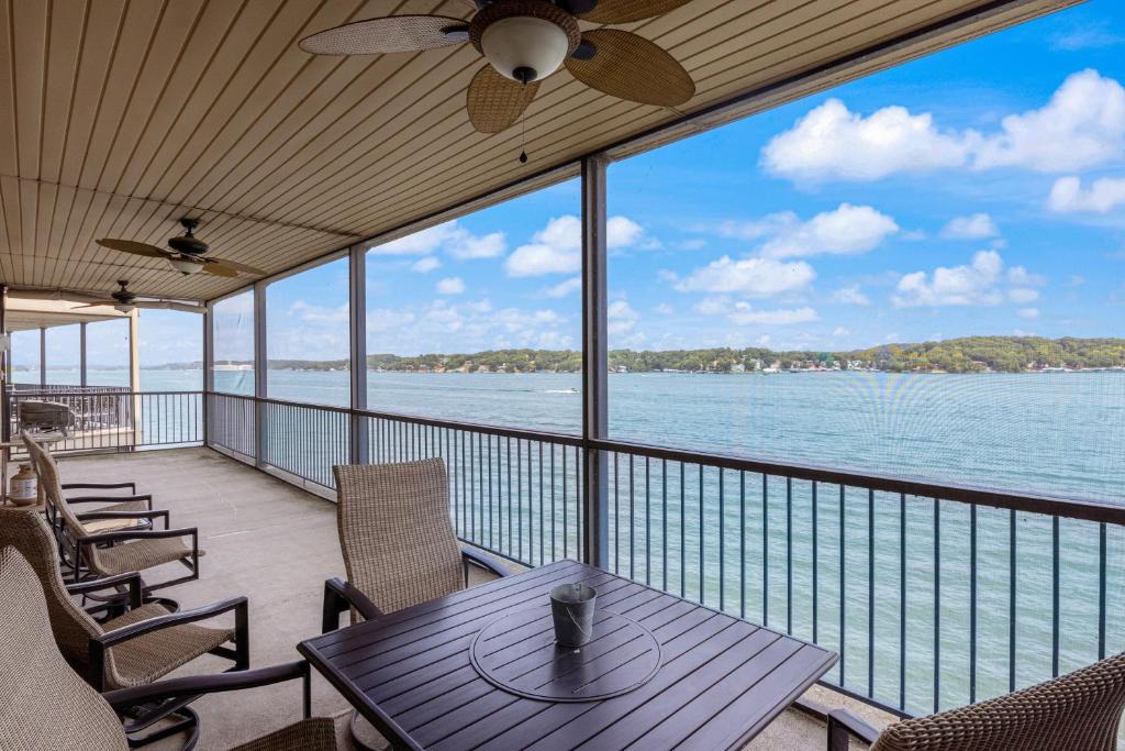 a balcony with a table and chairs and the water at On a Point in Lake Ozark