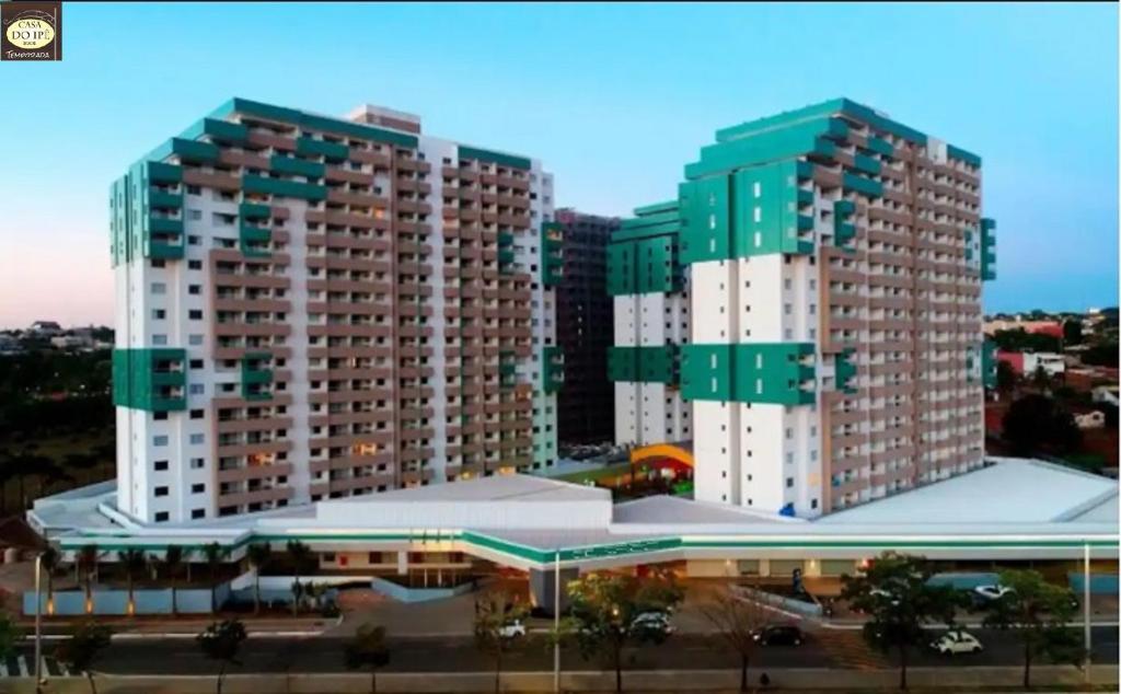 zwei hohe Gebäude in einer Stadt neben einem Gebäude in der Unterkunft Apto do Veloso no Resort in Olímpia