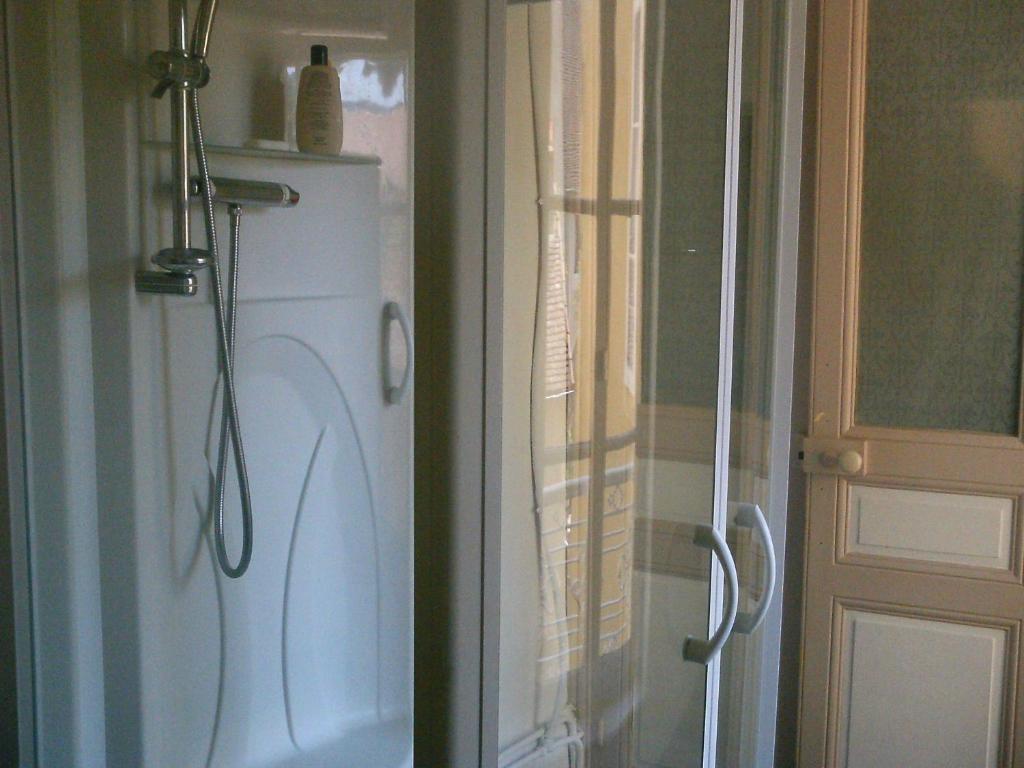 een badkamer met een douche en een witte koelkast bij Chambre d'hôte, 3 pièces 90m2 in Autun