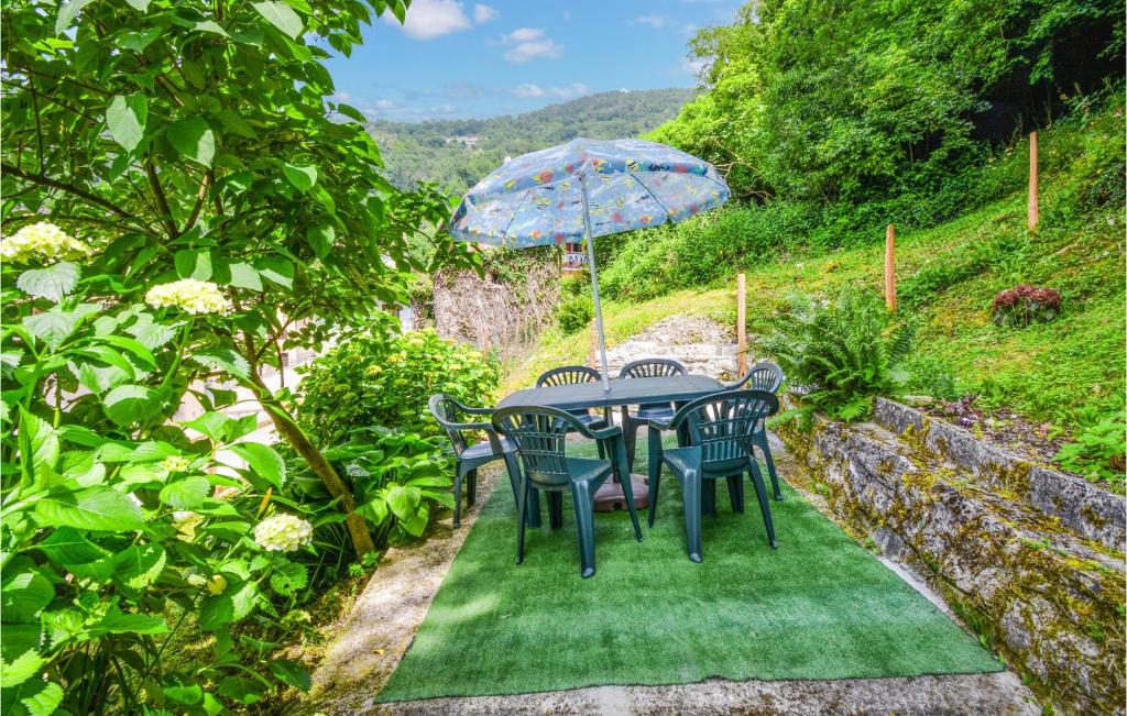 una mesa y sillas con una sombrilla en el jardín en Nice Home In Lusiana With Kitchen, en Lusiana
