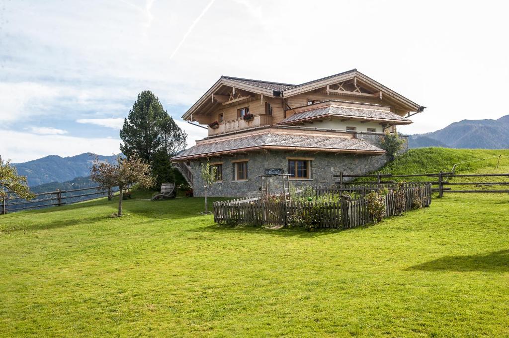 ein Haus auf einem Hügel mit einem Zaun davor in der Unterkunft Chalet Winterbauer in Flachau