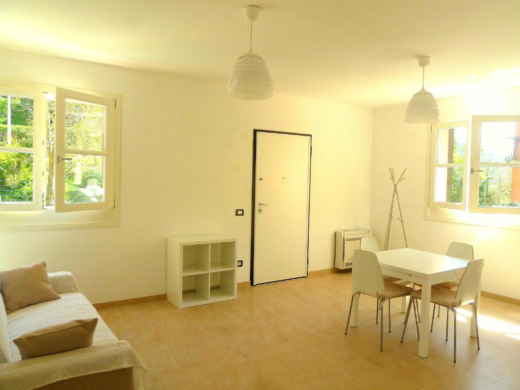 uma sala de estar branca com uma mesa e uma porta em Al Molino delle Ghiare em Levanto