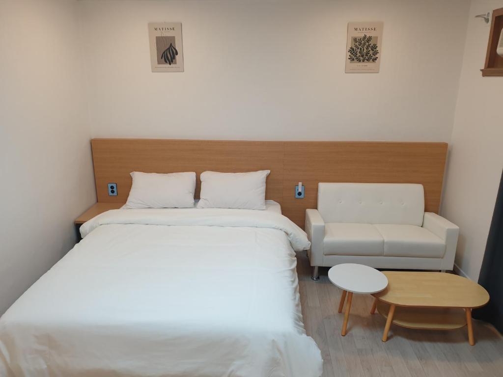 a bedroom with a bed and a couch and a chair at Seorak HOT Spring Mammoth Resotel in Sokcho