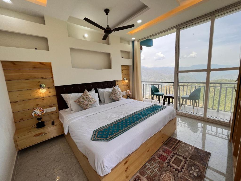 a bedroom with a large bed and a large window at Nature Heaven Lodge, Mussoorie in Mussoorie