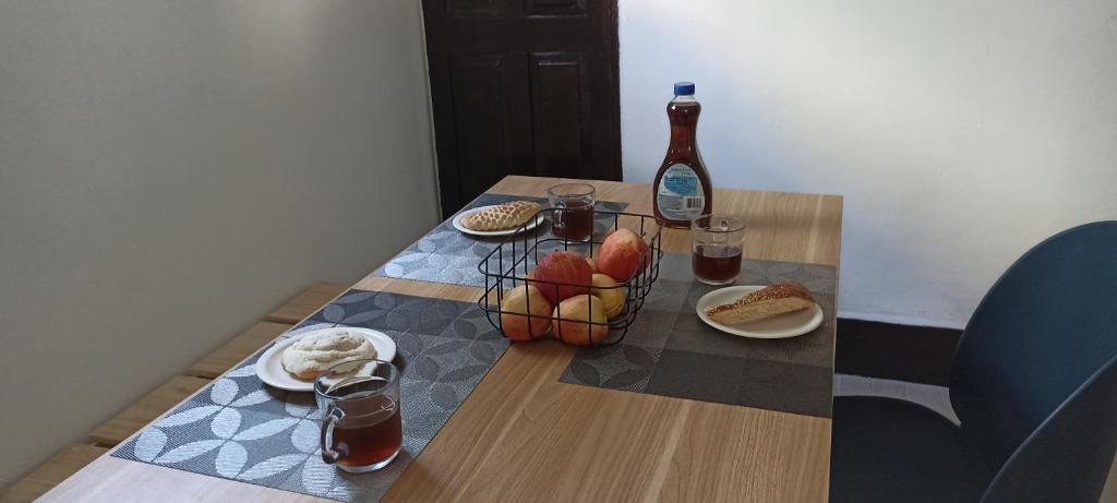 einen Holztisch mit Essen und einer Flasche Wein in der Unterkunft Hostal Casa Azul, doble in Orizaba