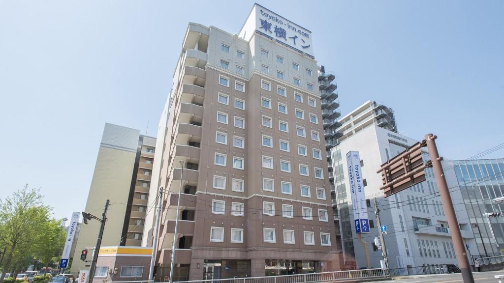 a tall brown building on a city street at Toyoko Inn Fukushima-eki Higashi-guchi No 2 in Fukushima