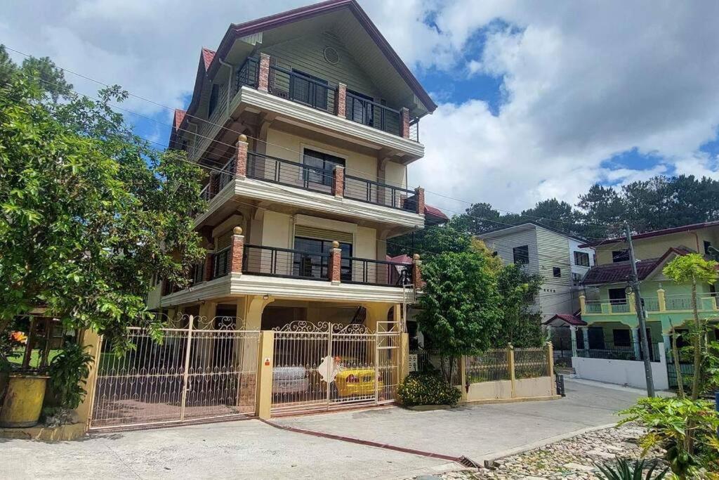 una casa grande con una valla delante en Malbros guest house en Baguio