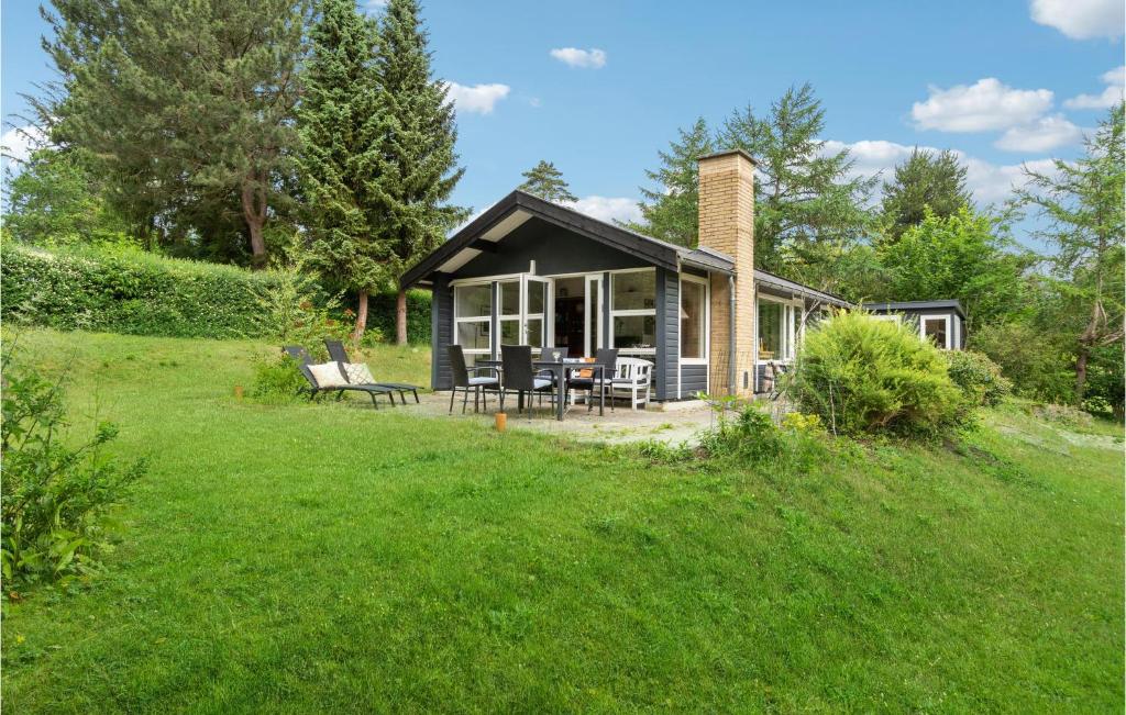 ein kleines Haus mit einer Terrasse und einem Rasenplatz in der Unterkunft Nice Home In Vejby With Kitchen in Vejby