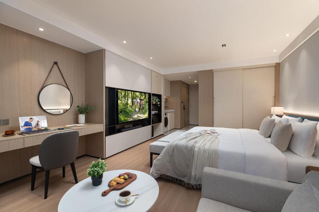 a bedroom with a bed and a living room at Somerset Taihu New City CBD Wuxi in Wuxi