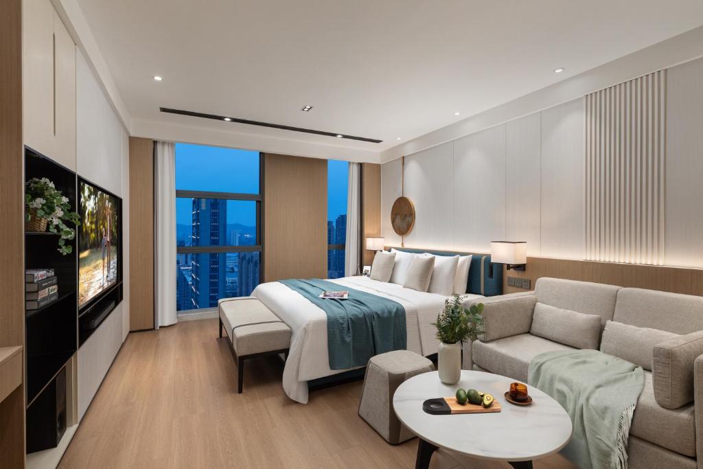 a hotel room with a bed and a couch at Somerset Taihu New City CBD Wuxi in Wuxi