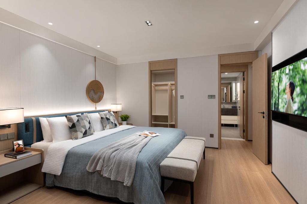 a bedroom with a bed and a flat screen tv at Somerset Taihu New City CBD Wuxi in Wuxi