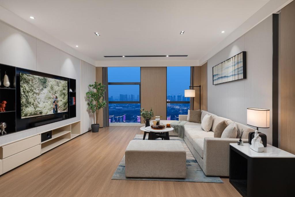 a living room with a couch and a tv at Somerset Taihu New City CBD Wuxi in Wuxi