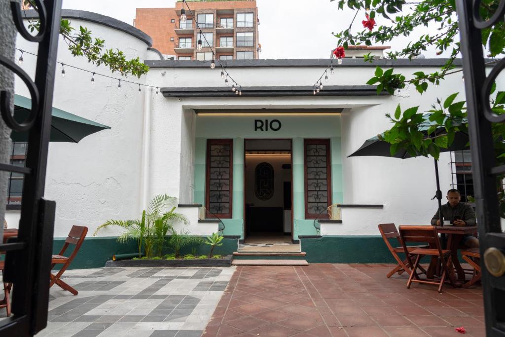 RIO HOSTEL في غواتيمالا: رجل يجلس على طاولة أمام المبنى