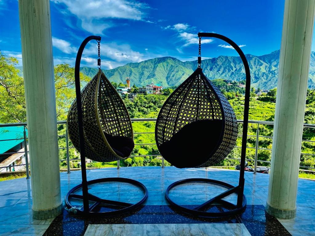 een schommel op een veranda met uitzicht op de bergen bij Sitara Hotel & Resort, ! Most Awarded Property in Mussoorie in Mussoorie