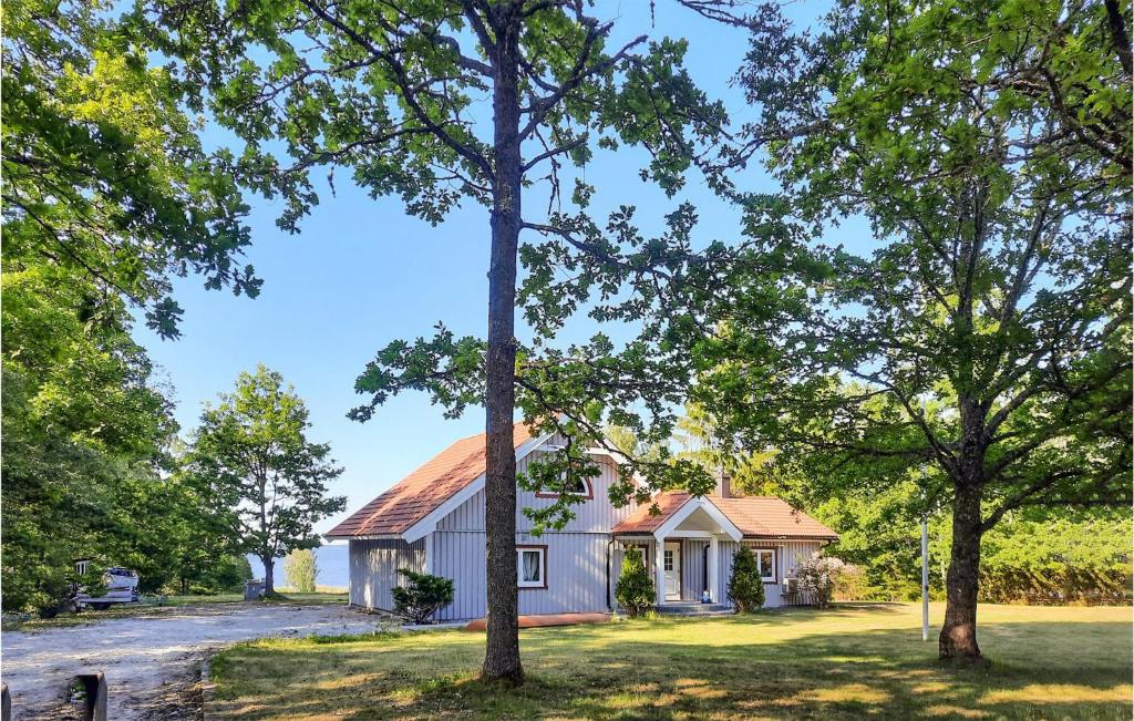 une maison blanche avec des arbres devant elle dans l'établissement Gorgeous Home In Stora Mellsa With Kitchen, à Stora Mellösa