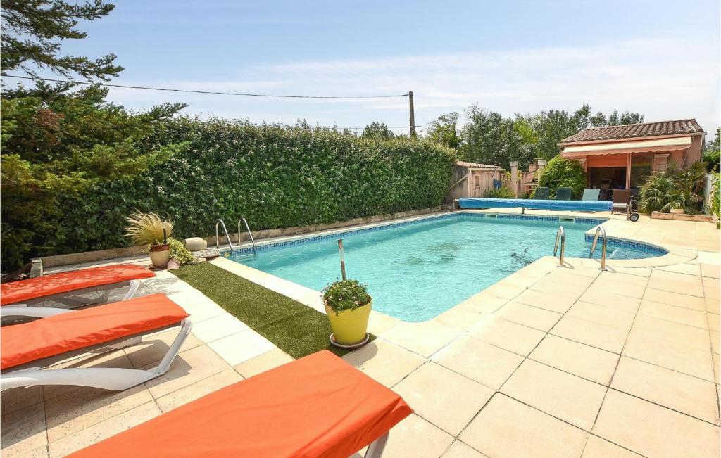 une piscine dans une cour avec deux chaises orange dans l'établissement Pet Friendly StaCaravan, à Entraigues-sur-la-Sorgue
