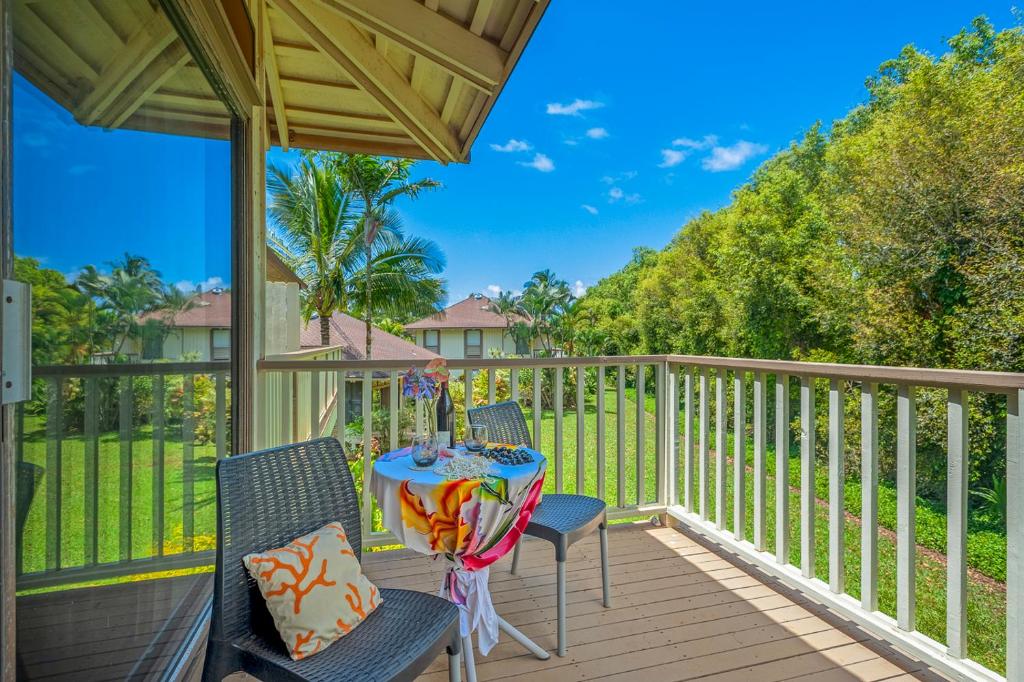 a patio with chairs and a table on a deck at Spacious Princeville studio in Princeville