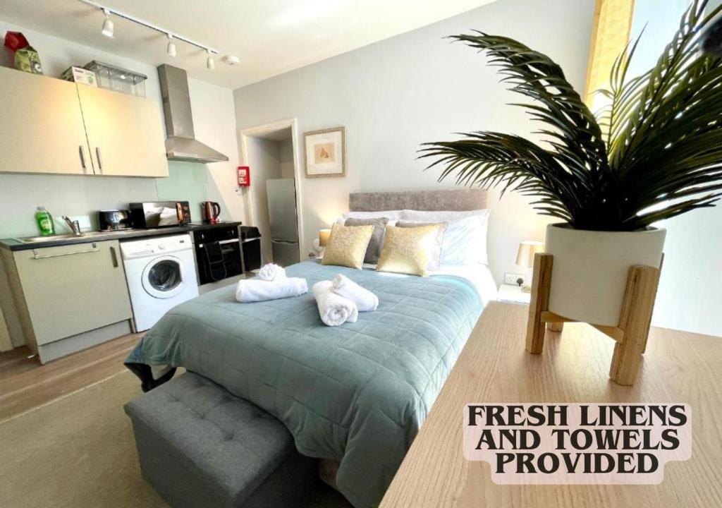 um quarto com uma cama com toalhas em Cute and cosy studio in a Fantastic Location! BISHOPS STORTFORD em Bishop's Stortford