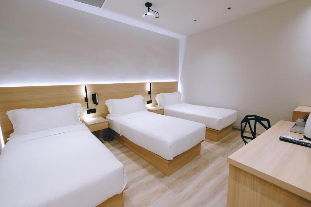 Giường trong phòng chung tại Rest Bugis Hotel