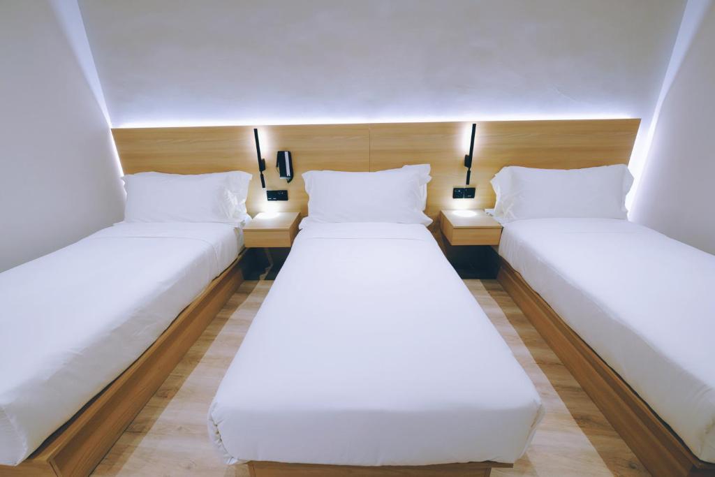 Giường trong phòng chung tại Rest Bugis Hotel