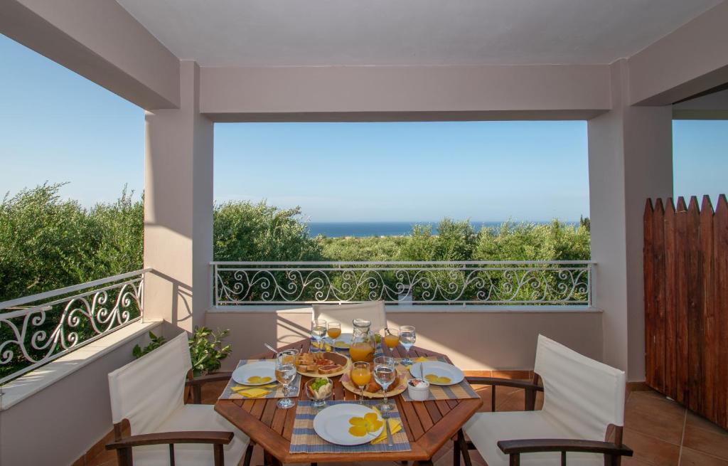 - Mesa de comedor en el balcón con vistas al océano en Villa Zoi, en Méson Yerakaríon