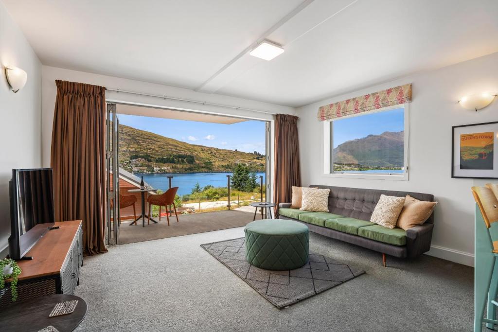 a living room with a couch and a large window at Lakeside Living - 1 Bedroom Alpine Apartment 1 in Queenstown