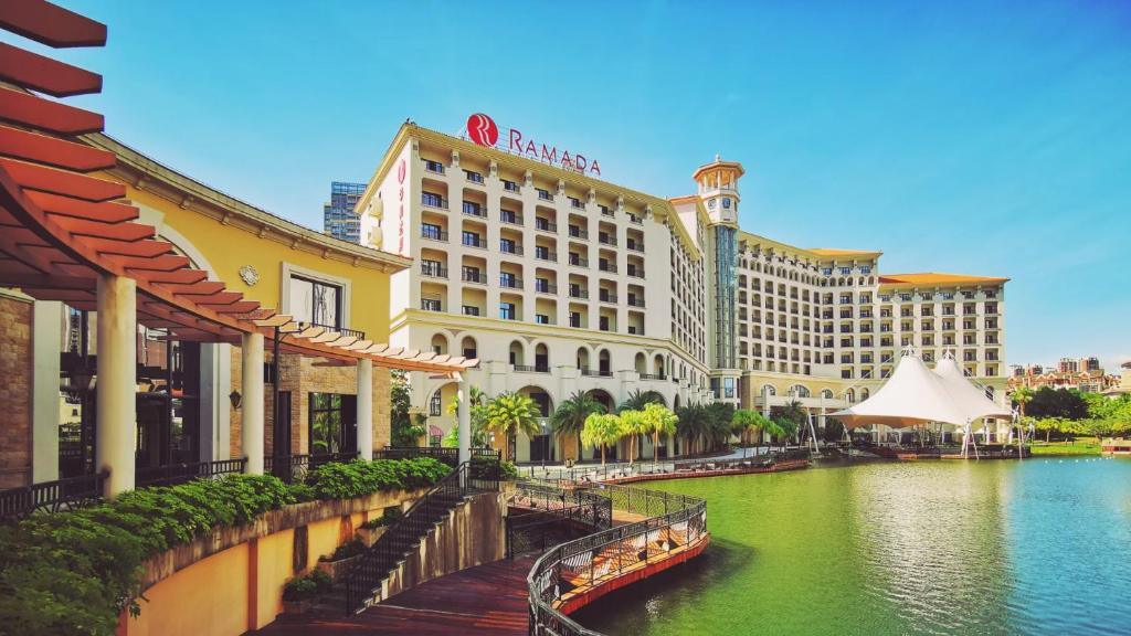 a view of a hotel and a river with buildings at Ramada By Wyndham Huizhou South in Huizhou