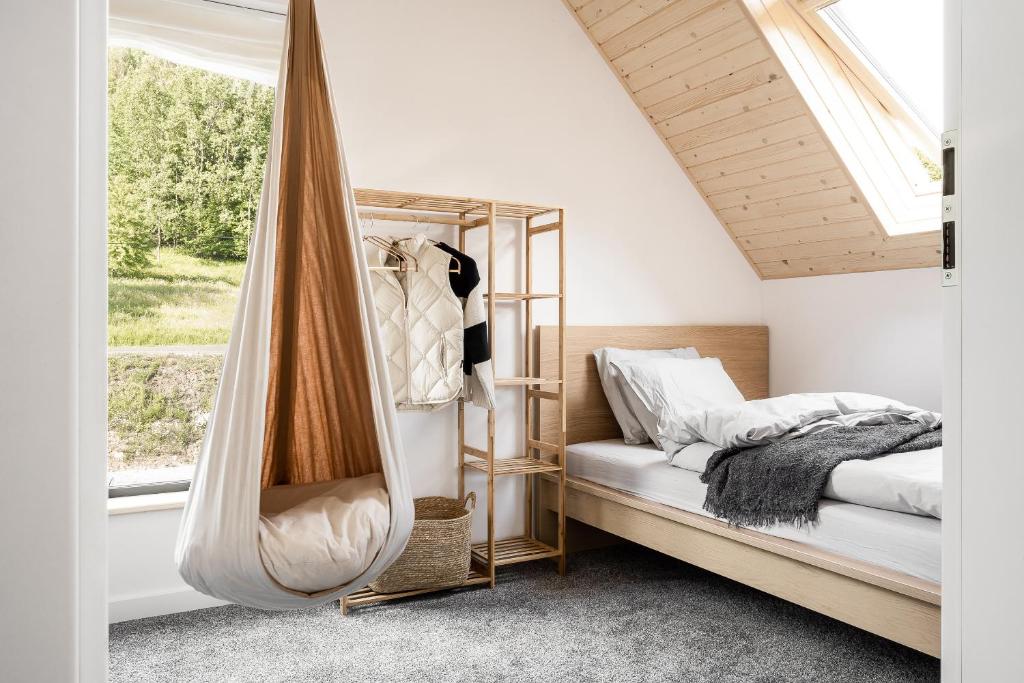 扎沃亚Babia Rest - całoroczny domek z balią z jacuzzi的卧室配有一张床和窗户旁的吊床