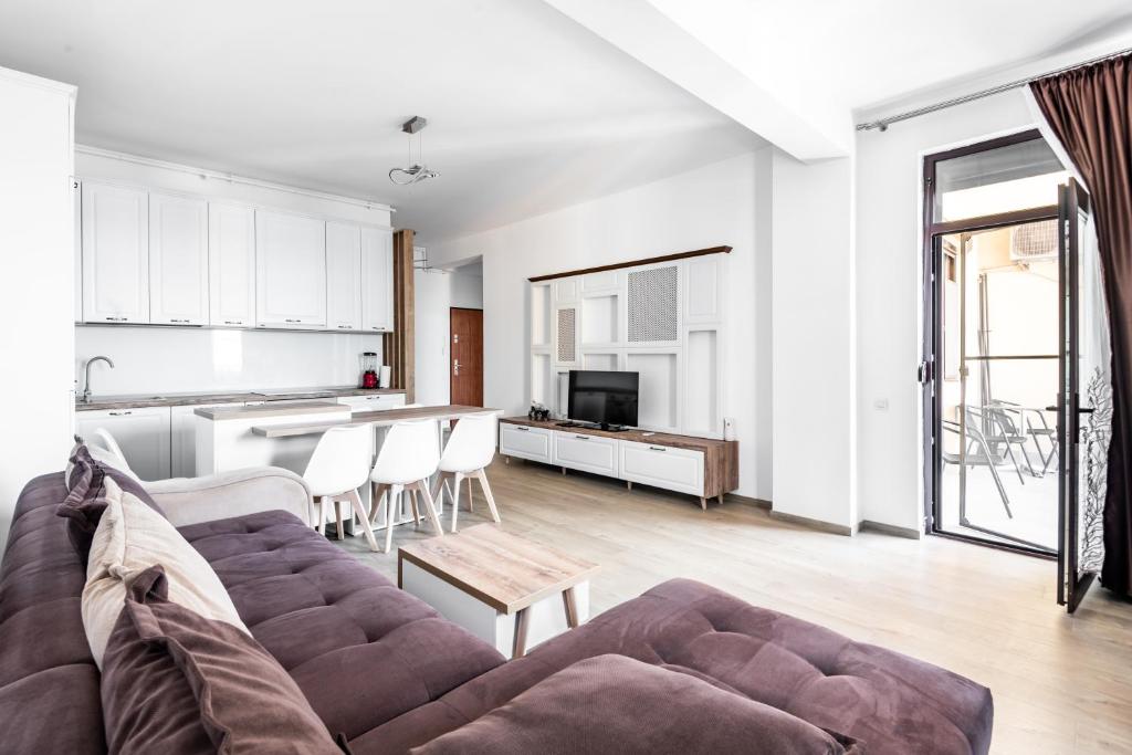 a living room with a couch and a kitchen at SnS Apartament Regal in Mamaia