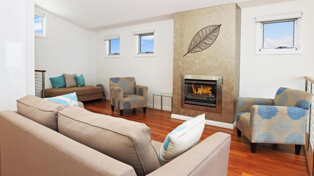 a living room with a couch and a fireplace at Surf Mist in Gerroa