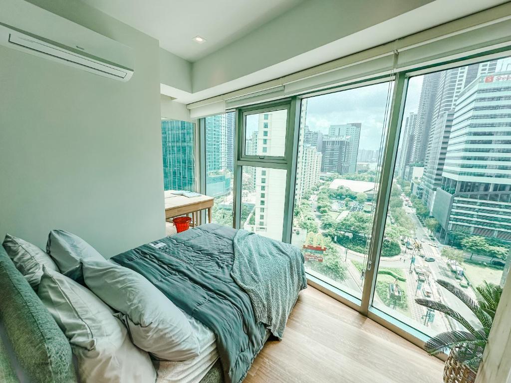 a bedroom with a bed and a large window at Vibrant Oasis with the best view + Fast WiFi in Manila