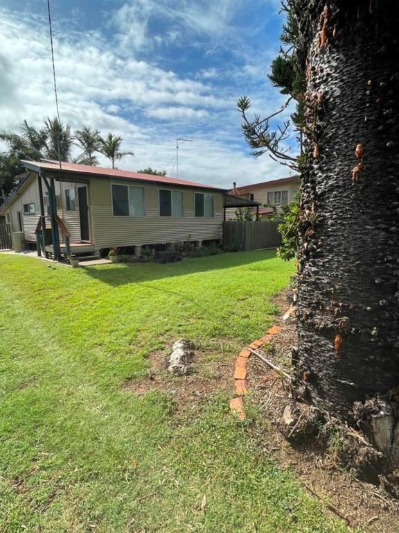 a house in a yard with a yard at Keppel Cottage - 7 Limpus Avenue Keppel Sands in Keppel Sands