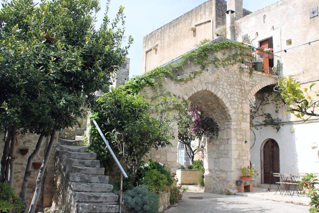 an old stone building with stairs and an archway at Casa masseria dell'800 Gargano. Le Mignole in Monte SantʼAngelo
