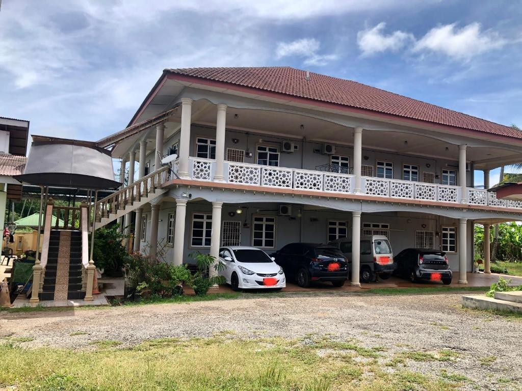 a large house with cars parked in front of it at Homestay Seri Hampar, Pendang in Pendang