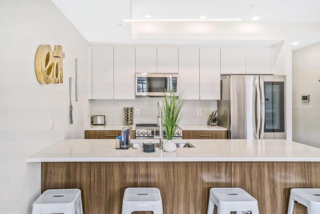 a kitchen with white cabinets and white counter tops at Luxurious and stylish 2 bedroom 2 bathroom suite in Washington, D.C.