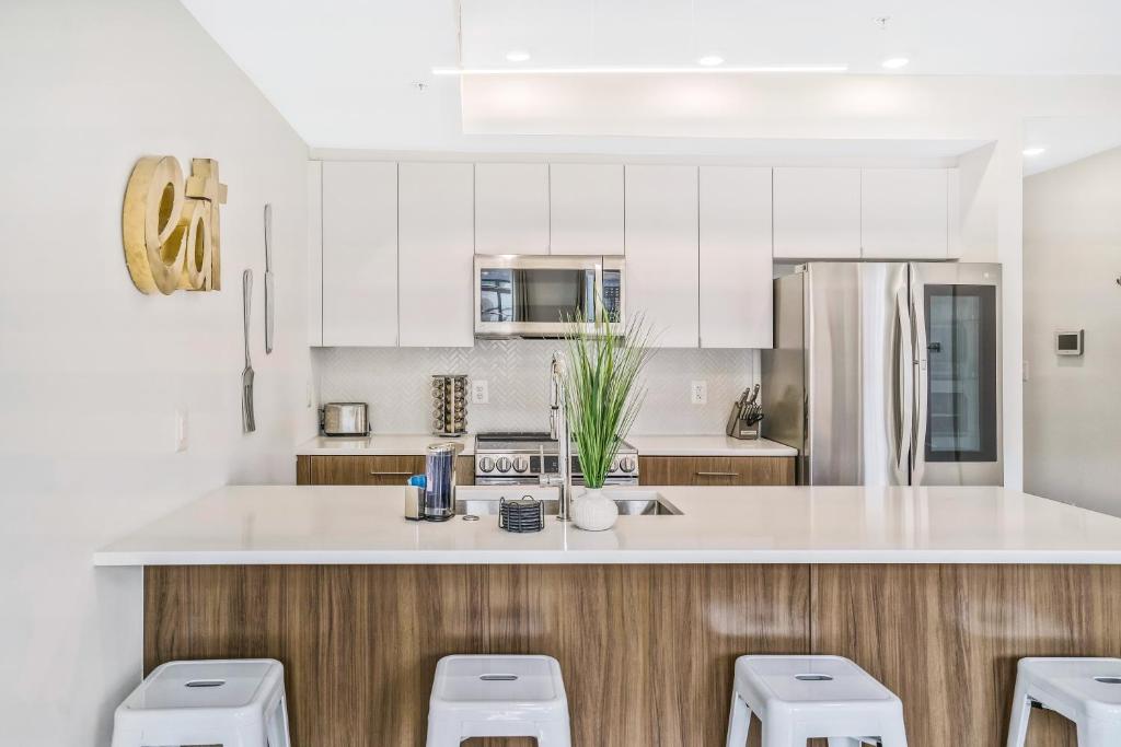 a kitchen with white cabinets and white counter tops at Luxurious and stylish 2 bedroom 2 bathroom suite in Washington