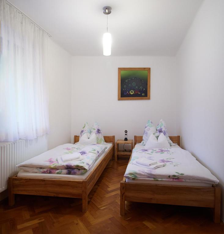 two twin beds in a room with a window at KeramikArt-Wohnung in Pécs